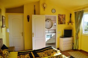 a yellow room with a bedroom with a sink at Can Tapsy in Tossa de Mar