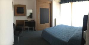 um quarto com uma cama, uma secretária e uma cozinha em Albergo Valle d'Oro em Albino