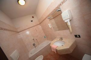 La salle de bains est pourvue d'un lavabo, d'une baignoire et de toilettes. dans l'établissement Albergo Valle d'Oro, à Albino