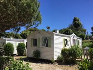 a white holiday house with trees and bushes at Camping Barataud in Saint-Denis-dʼOléron
