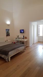 een witte slaapkamer met een bed en een bureau bij Il Cortile del Marchese Beccadelli in Sambuca di Sicilia