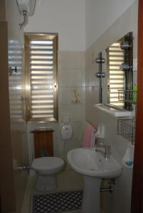 a white bathroom with a sink and a toilet at Hotel "Locanda Gaia" in Muggia