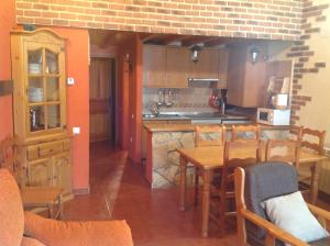cocina y comedor con mesa y sillas en Casa Rural La Vega De Gredos, en San Martín de la Vega del Alberche