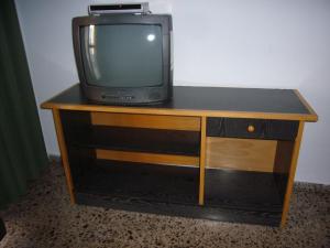 a small television sitting on top of a wooden cabinet at Finlandia - Fincas Arena in Benidorm