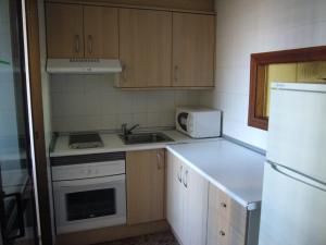 a small kitchen with a sink and a refrigerator at Finlandia - Fincas Arena in Benidorm