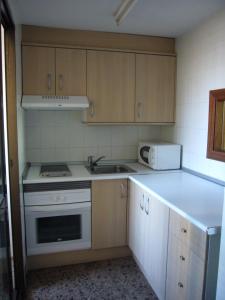 a kitchen with a sink and a stove and cabinets at Finlandia - Fincas Arena in Benidorm