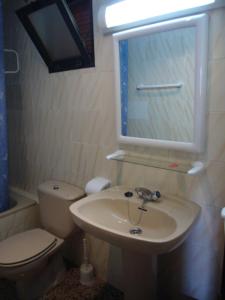 a bathroom with a sink and a toilet and a mirror at Finlandia - Fincas Arena in Benidorm