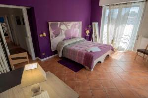 a bedroom with a bed with a purple wall at Affittacamere Caffè Nazionale in Stresa