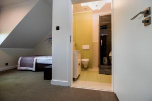 a bathroom with a toilet and a bed in a room at Apartamenty Giżycko in Giżycko +121 photos