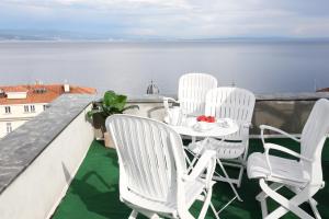 una mesa y sillas en un balcón con vistas al agua en Paradise View deluxe apartment, en Opatija