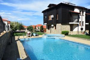 a swimming pool in front of a house at Paradise Bay Villas in Sozopol