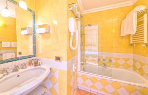 a bathroom with a sink, mirror, and bathtub at Miramare E Castello in Ischia