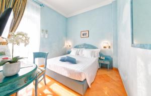 a blue bedroom with a bed and a desk at Miramare E Castello in Ischia