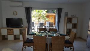 a dining room with a table with chairs and a television at Maison Provost in Le Croisic