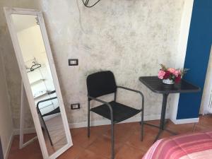 una sedia nera e uno specchio in una stanza di Affittacamere Caffè Nazionale a Stresa