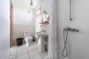 a white bathroom with a toilet and a sink at Oasis Club Cottages in Udabno
