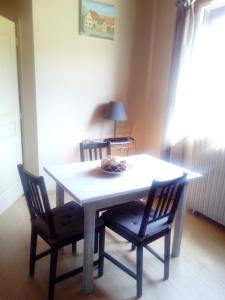 een eettafel met 2 stoelen en een tafel en een lamp bij Chambre d'hotes des Poisets in Crotenay