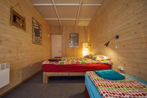2 Betten in einem Zimmer mit Holzwänden in der Unterkunft Oasis Club Cottages in Udabno