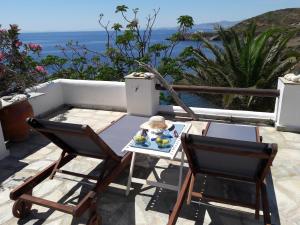 einen Tisch und Stühle auf einer Terrasse mit Meerblick in der Unterkunft Exclusive Beach House in Gavrio