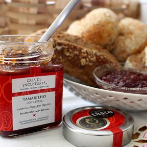 a table with a jar of jam and a bowl of bread at Casa de Encosturas in Cabeceiras de Basto