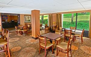 a dining room with tables and chairs and windows at Baymont by Wyndham Branson - On the Strip in Branson