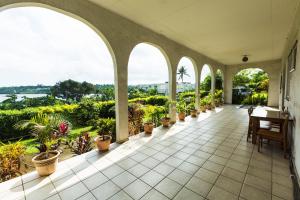 a porch with arches and potted plants at Room With A View & Apartment Style in Port Vila