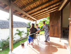 a group of people standing on the porch of a house at Room With A View & Apartment Style in Port Vila