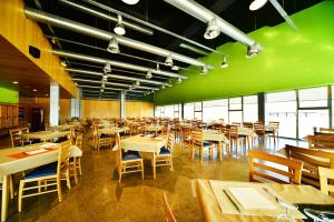 a restaurant with tables and chairs and a green wall at Hotel Área Suco in Quintana del Puente