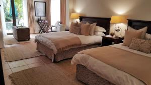 1 dormitorio con 2 camas y almohadas en Riversong Guest House, en Ciudad del Cabo