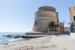 un viejo faro en la playa junto al océano en Viale Hanbury, en Alassio