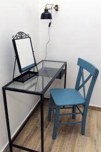 a glass desk with a chair and a lamp at Blue Box Apartment in Belgrade