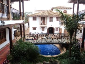 a bridge over a pool in front of a building at Hotel Boutique Villa Roma in Villa de Leyva