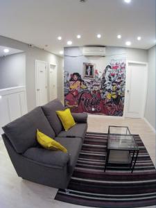 uma sala de estar com um sofá e um mural em Pensao Estacao Central em Lisboa