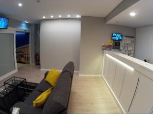 a living room with a couch with yellow pillows at Pensao Estacao Central in Lisbon
