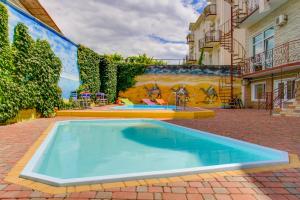 a swimming pool in a courtyard with a mural at Near Camel’s Humps Hotel in Koktebel