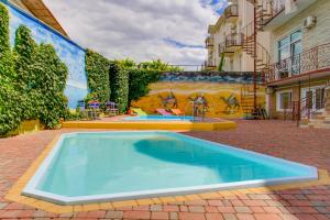 una piscina en un patio con un mural en Near Camel’s Humps Hotel, en Koktebel