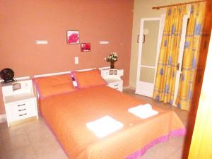 Almiros BeachにあるVilla Annaのベッドルーム1室(大型ベッド1台、オレンジのシーツ付)