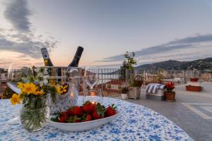 una mesa con un tazón de flores y botellas de vino en La Tortuga, en Agropoli