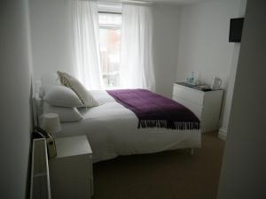 a bedroom with a white bed and a window at The Crown Rooms Newmarket in Newmarket