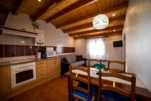 a kitchen with a table and a dining room at Monte do Zeca in Zambujeira do Mar