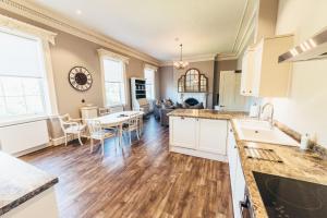 a kitchen and living room with a table and chairs at Birchover Bridgford Hall in Nottingham