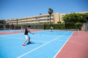 twee mannen tennissen op een tennisbaan bij Sunshine Rhodes in Ialyssos