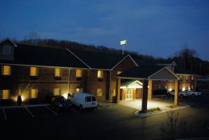 un bâtiment avec une camionnette blanche garée dans un parking dans l'établissement Mountain Inn & Suites Airport - Hendersonville, à Hendersonville