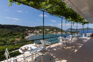 a balcony with white chairs and a view of the water at Apartments Miskovic in Koločep