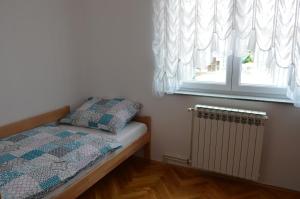 a small bedroom with a bed and a window at Apartment Sarah in Bihać