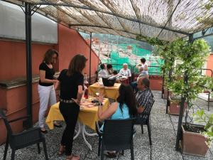 un grupo de personas sentadas en mesas en un restaurante en Hotel Cortina, en Garda