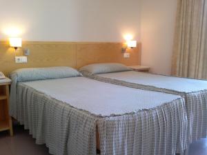 2 letti in camera d'albergo con 2 lampade di Pensión Balcones Azules a Cartagena