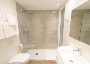 a bathroom with a shower and a toilet and a sink at Grand Hotel Liberty in Riva del Garda