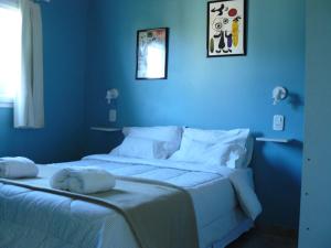 1 dormitorio azul con 2 camas con sábanas blancas en Altos de Ayelen, en Esquel