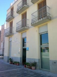 un edificio bianco con balconi e una porta di Pensión Balcones Azules a Cartagena